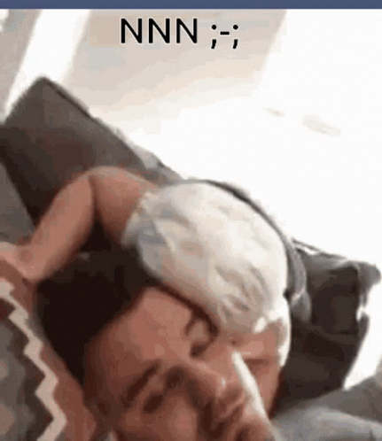 A Man Is Laying On A Couch With A Cat On His Head And The Word Nnn Is On The Bottom GIF