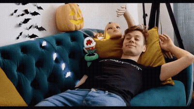 A Man Is Laying On A Couch With A Stuffed Animal And A Pumpkin . GIF