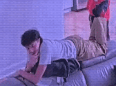 A Man Is Laying On A Couch With His Legs Up . GIF