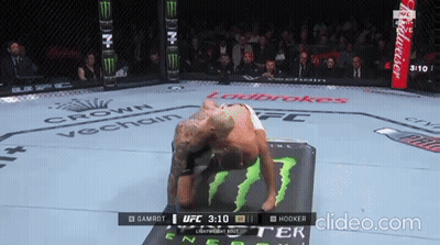 A Man Is Laying On A Mat In A Boxing Ring With A Budweiser Ad In The Background GIF