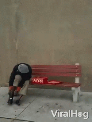A Man Is Laying On A Red Bench With A Pizza Box On It . GIF