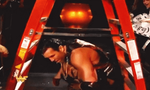 A Man Is Laying On A Red Ladder With A Sign That Says Angry Guy GIF