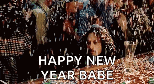A Man Is Laying On A Table With Confetti Falling On Him And A Glass Of Champagne . GIF