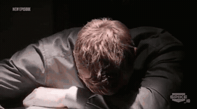 A Man Is Laying On A Table With His Head On His Hands . GIF