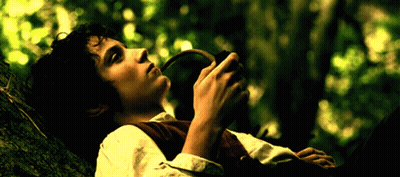 A Man Is Laying On A Tree Branch Holding A Pipe In His Hand GIF