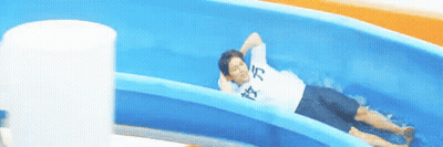 A Man Is Laying On A Water Slide Wearing A Shirt That Says ' I 'M Tired ' On It GIF