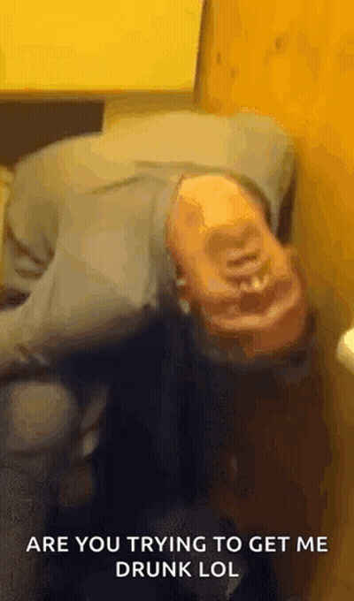 A Man Is Laying On His Back In A Bathroom With The Words `` Are You Trying To Get Me Drunk Lol '' Above Him . GIF