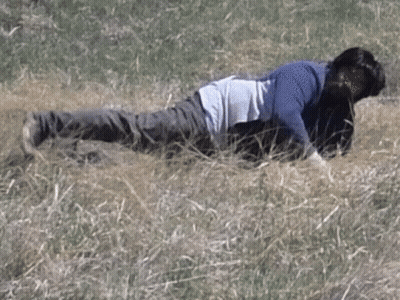 A Man Is Laying On His Back In The Grass . GIF