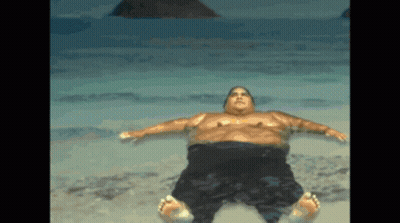 A Man Is Laying On His Back On The Beach GIF