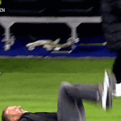 A Man Is Laying On His Stomach On A Soccer Field GIF