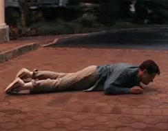 A Man Is Laying On His Stomach On The Ground GIF