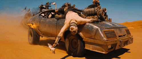 A Man Is Laying On The Back Of A Dirty Car GIF