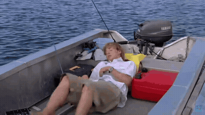A Man Is Laying On The Deck Of A Boat With A Yamaha Motor GIF