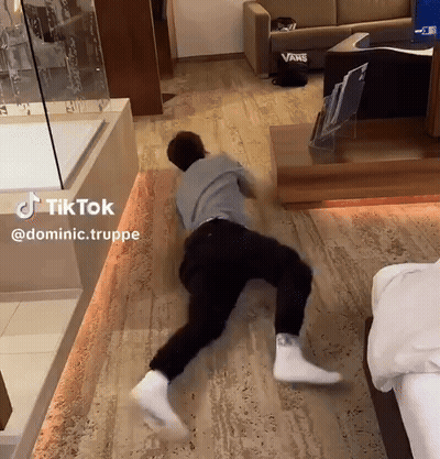 A Man Is Laying On The Floor In A Room With A Vans Couch GIF