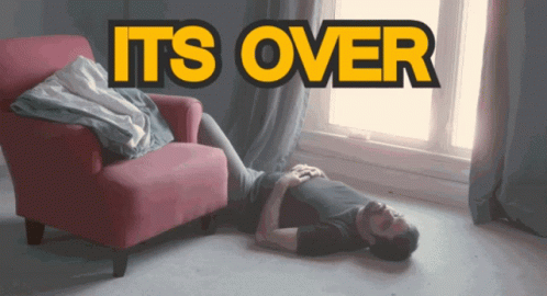 A Man Is Laying On The Floor In Front Of A Chair With The Words " It 'S Over " Above Him GIF