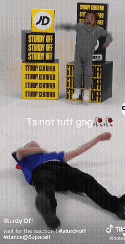 A Man Is Laying On The Floor In Front Of A Jd Sign GIF
