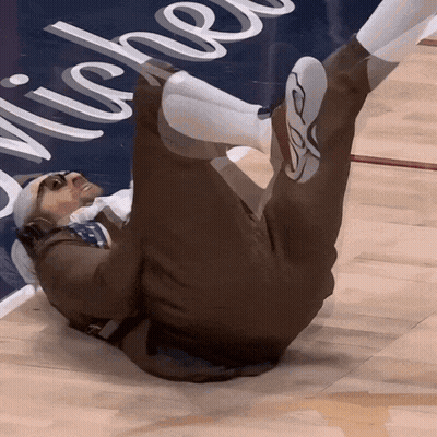 A Man Is Laying On The Floor In Front Of A Sign That Says " Michel " GIF