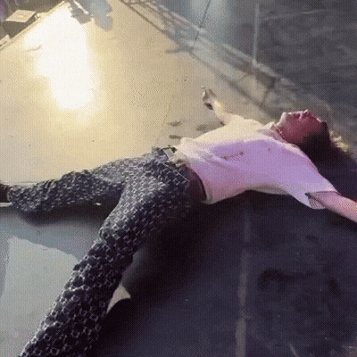 A Man Is Laying On The Floor With His Arms Outstretched GIF
