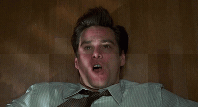 A Man Is Laying On The Floor With His Hands On His Face . GIF