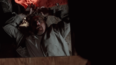 A Man Is Laying On The Floor With His Mouth Open And His Hands In The Air . GIF