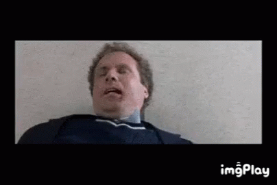 A Man Is Laying On The Floor With His Mouth Open And His Tongue Out . GIF