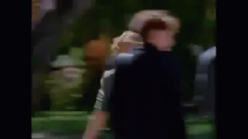 A Man Is Laying On The Grass In A Park . GIF