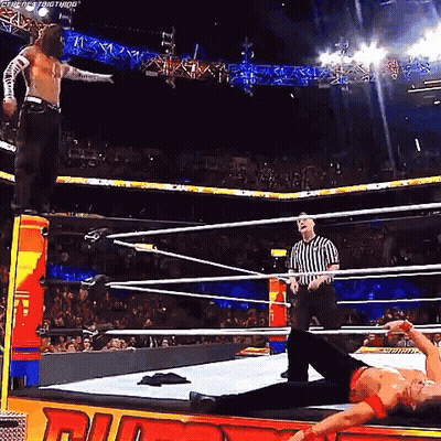 A Man Is Laying On The Ground In A Wrestling Ring While A Referee Watches GIF
