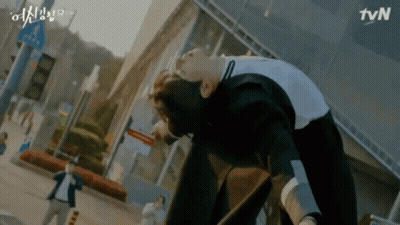 A Man Is Laying On The Ground In Front Of A Tvn Building . GIF