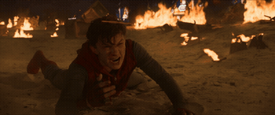 A Man Is Laying On The Ground In Front Of Fires GIF