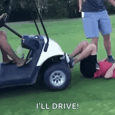 A Man Is Laying On The Ground Next To A Golf Cart While Another Man Stands Behind Him . GIF