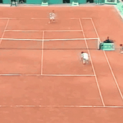 A Man Is Laying On The Ground On A Tennis Court GIF