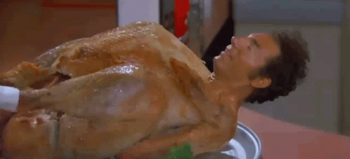 A Man Is Laying On Top Of A Roasted Turkey GIF