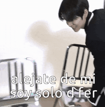 A Man Is Leaning Over A Chair With The Words " Alejate De Mi Soy Solo D Fer " Written On It GIF