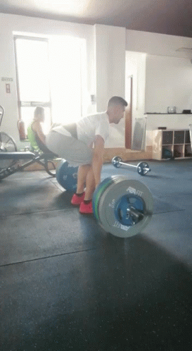 A Man Is Lifting A Barbell In A Gym That Says ' Rogue ' On It GIF