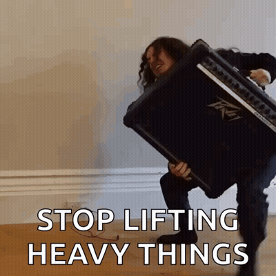 A Man Is Lifting An Amplifier With The Words Stop Lifting Heavy Things Written Below Him GIF
