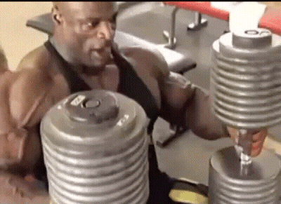A Man Is Lifting Dumbbells In A Gym While Sitting On A Bench . GIF