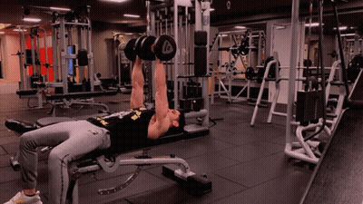 A Man Is Lifting Dumbbells In A Gym With The Letter A On The Dumbbell GIF