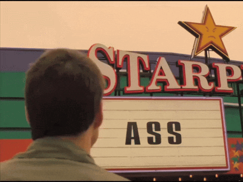 A Man Is Looking At A Starp Sign That Says Ass GIF