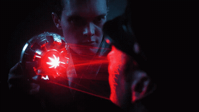A Man Is Looking At Another Man With A Red Light Coming Out Of His Face GIF