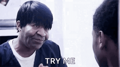 A Man Is Looking At Himself In A Mirror And Saying `` Try Me '' While Talking To Another Man . GIF