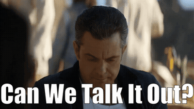 A Man Is Looking Down With The Words Can We Talk It Out Behind Him GIF