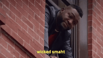 A Man Is Looking Out Of A Window With The Words Wicked Smaht Written On The Brick Wall Behind Him . GIF