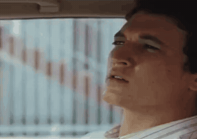 A Man Is Looking Out The Window Of A Car . GIF