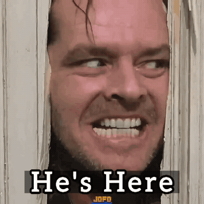A Man Is Looking Through A Door With The Words He 'S Here Behind Him GIF