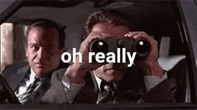 A Man Is Looking Through Binoculars In A Car While Another Man Looks Out The Window . GIF