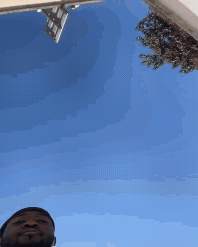 A Man Is Looking Up At A Blue Sky GIF