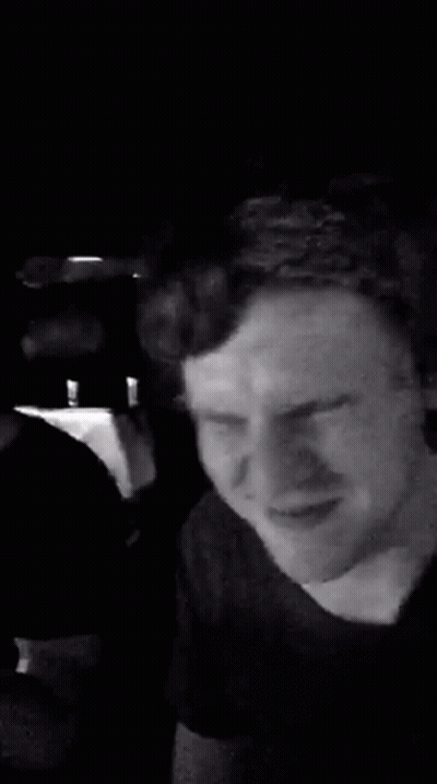 A Man Is Making A Funny Face In A Black And White Photo While Sitting In A Car . GIF