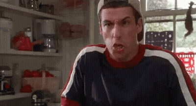 A Man Is Making A Funny Face In A Kitchen While Wearing A Baseball Cap . GIF