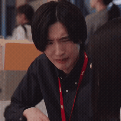 A Man Is Making A Funny Face While Sitting At A Table With His Hands Together . GIF
