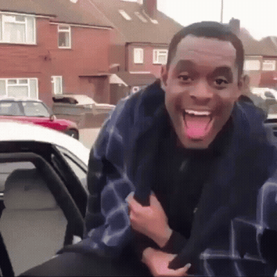 A Man Is Making A Funny Face While Sitting In A Car . GIF